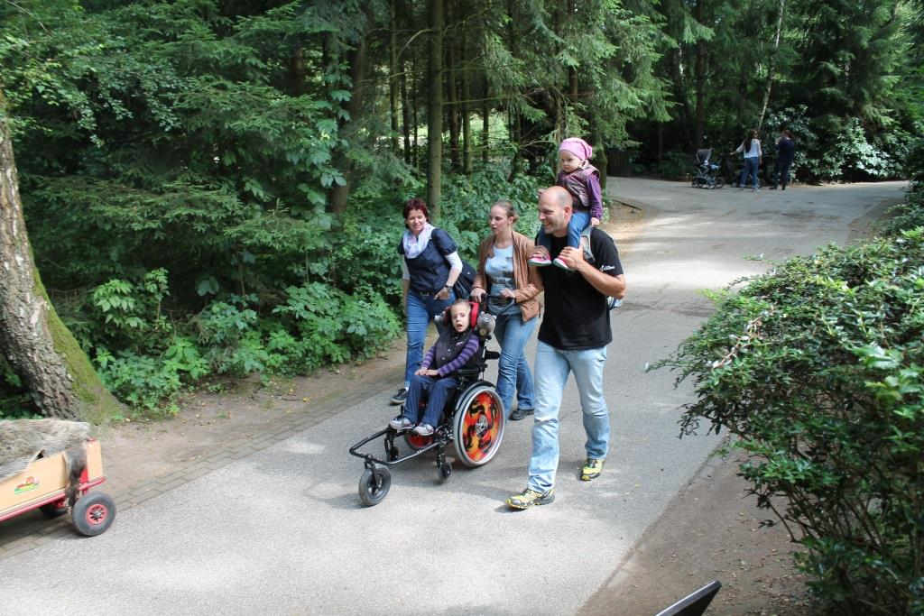 Familie mit Kind im Rollstuhl macht einen Ausflug im Wildpark Schwarze Berge
